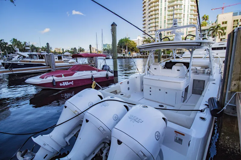 Slide: The Image of 2017 Everglades 360 LXC boat docked at marina with cityscape background. - 5