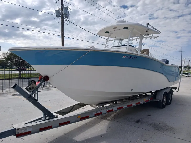 Slide: The Image of 2015 Sea Fox 286 Commander boat on trailer, blue and white hull, parked outdoors. - 2