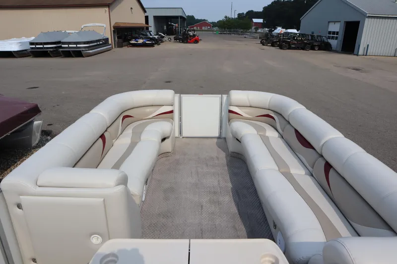Slide: The Image of 2005 Crest 25 Caribbean pontoon boat with spacious seating, parked in a marina lot. - 10