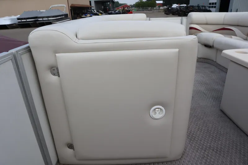 Slide: The Image of 2005 Crest 25 Caribbean boat interior with white cushioned seating and storage compartment. - 21