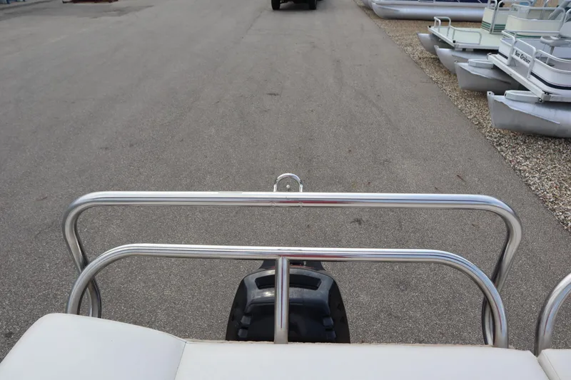 Slide: The Image of 2005 Crest 25 Caribbean pontoon boat, rear view with railing and motor, parked on pavement. - 44