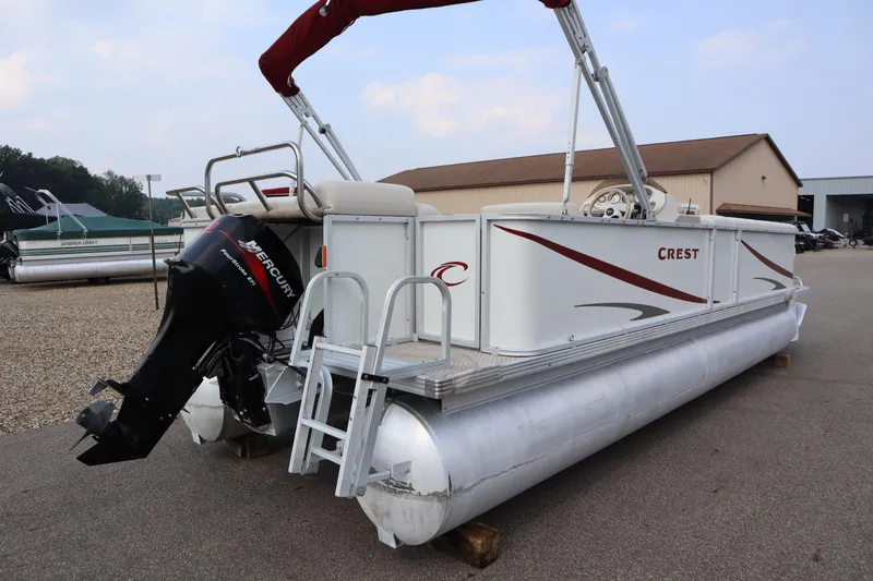 Slide: The Image of 2005 Crest 25 Caribbean pontoon boat with Mercury outboard motor, parked outdoors. - 5