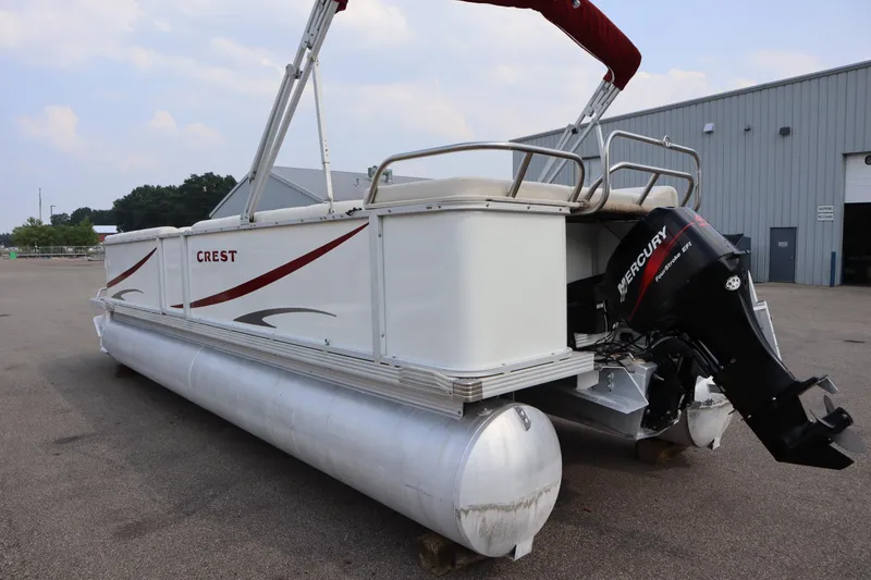 Slide: The Image of 2005 Crest 25 Caribbean pontoon boat with Mercury outboard motor, parked outdoors. - 7