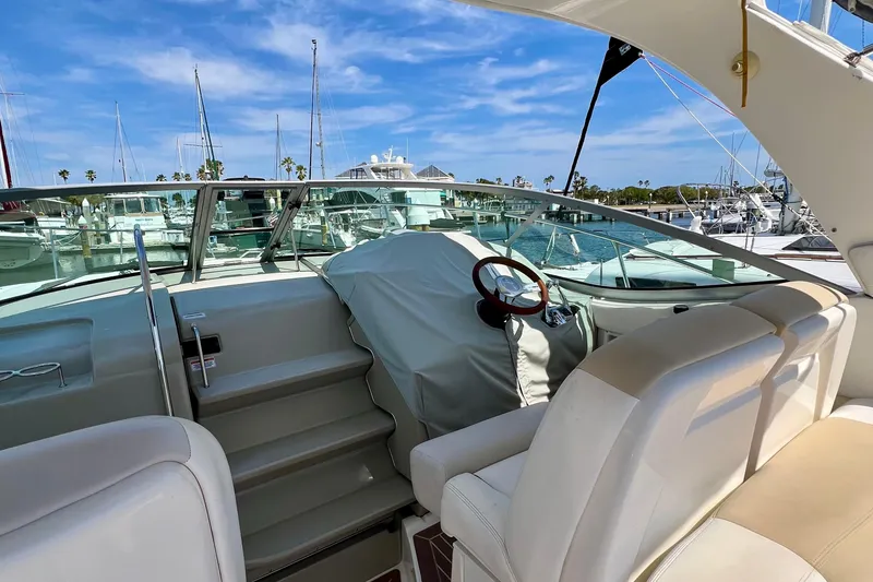 Slide: The Image of 2010 Sea Ray 350 Sundancer yacht interior with helm, docked at marina under blue sky. - 16