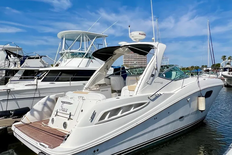 Slide: The Image of 2010 Sea Ray 350 Sundancer yacht docked at marina under clear blue sky. - 2