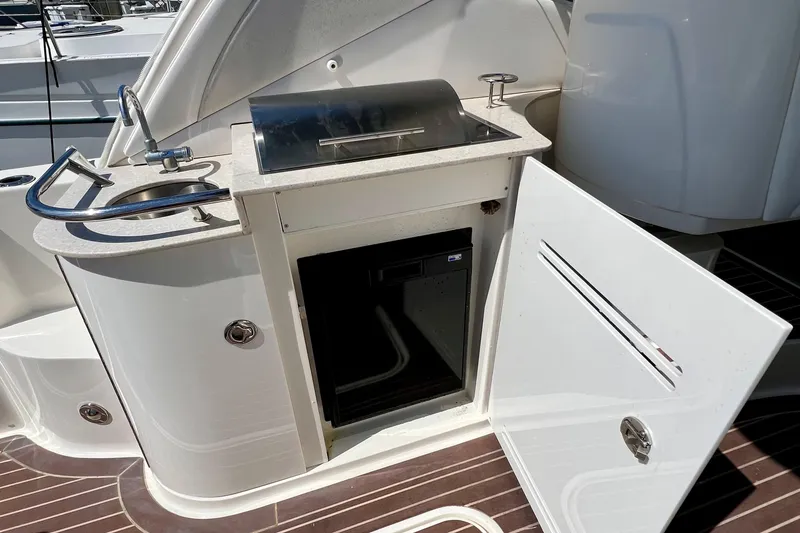 Slide: The Image of 2010 Sea Ray 350 Sundancer boat kitchenette with sink, grill, and storage. - 20