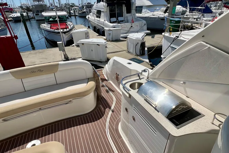 Slide: The Image of 2010 Sea Ray 350 Sundancer yacht interior with seating and kitchenette at marina. - 22