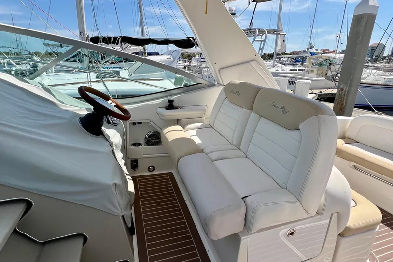 Slide: The Image of 2010 Sea Ray 350 Sundancer cockpit with white seating and wooden steering wheel. - 23