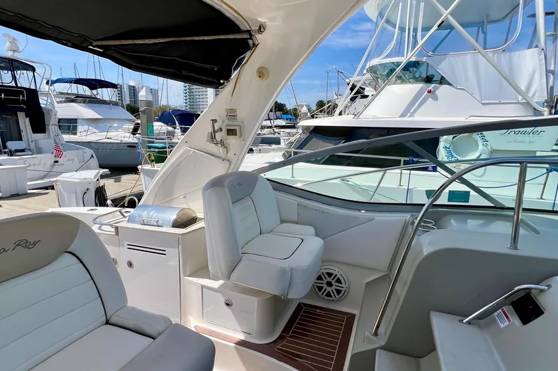 Slide: The Image of 2010 Sea Ray 350 Sundancer interior at marina, featuring comfortable seating and sleek design. - 24