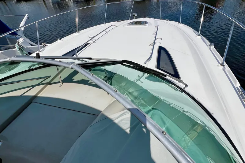 Slide: The Image of 2010 Sea Ray 350 Sundancer yacht deck with sleek design and clear windshield. - 26