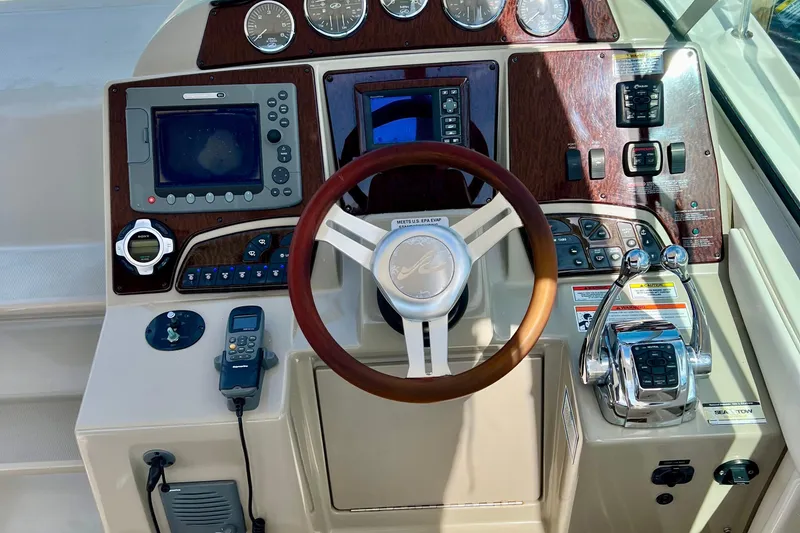 Slide: The Image of 2010 Sea Ray 350 Sundancer helm with wood accents and modern navigation controls. - 33
