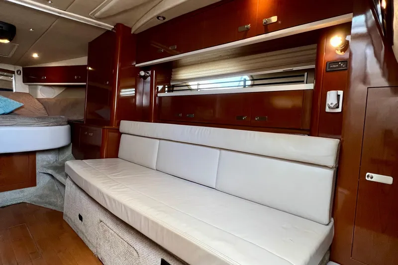 Slide: The Image of Interior of 2010 Sea Ray 350 Sundancer with white seating and wooden cabinetry. - 50