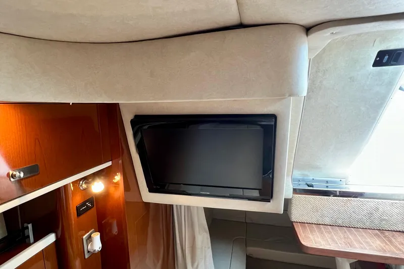 Slide: The Image of Interior of 2010 Sea Ray 350 Sundancer with mounted TV and wooden cabinetry. - 51
