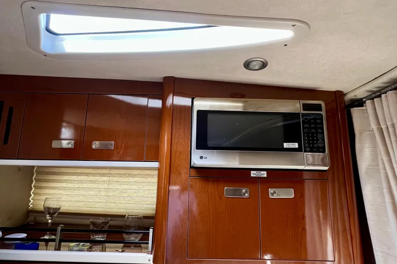 Slide: The Image of Interior of 2010 Sea Ray 350 Sundancer with wooden cabinets and built-in microwave. - 60
