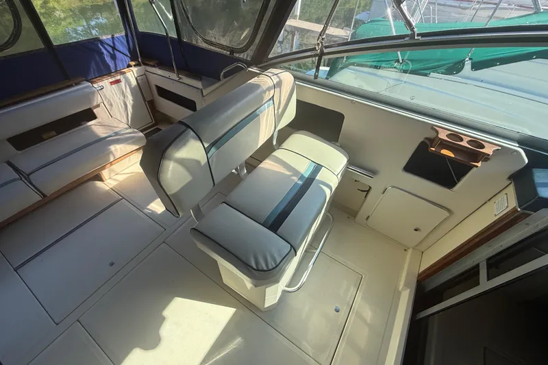 Slide: The Image of 1986 Sea Ray 300 Weekender interior with cushioned seating and cup holders. - 11