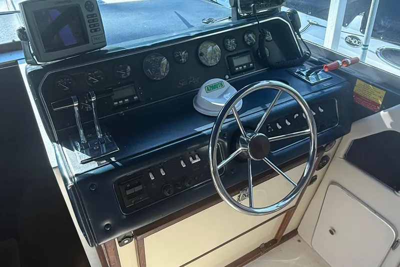 Slide: The Image of 1986 Sea Ray 300 Weekender helm with steering wheel and navigation instruments. - 13