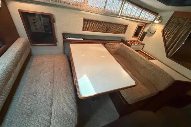 Slide: The Image of Interior of 1986 Sea Ray 300 Weekender with beige seating and a central table. - 16