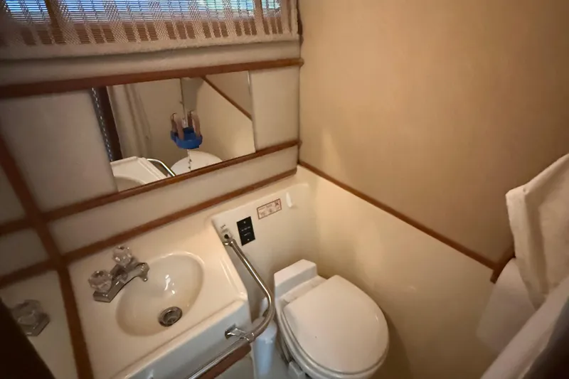 Slide: The Image of 1986 Sea Ray 300 Weekender bathroom with sink, toilet, and mirror. - 21
