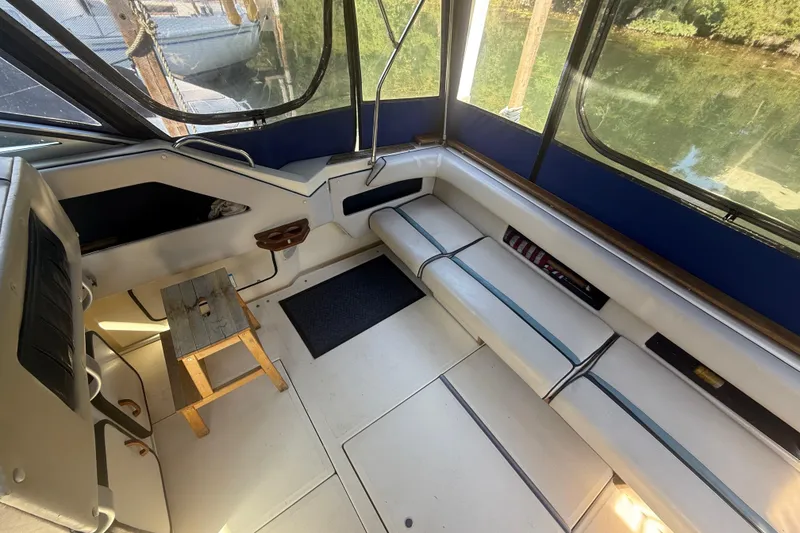 Slide: The Image of Interior of 1986 Sea Ray 300 Weekender boat with seating and wooden stool. - 7