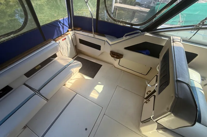 Slide: The Image of 1986 Sea Ray 300 Weekender interior with seating and windows, showcasing spacious design. - 9