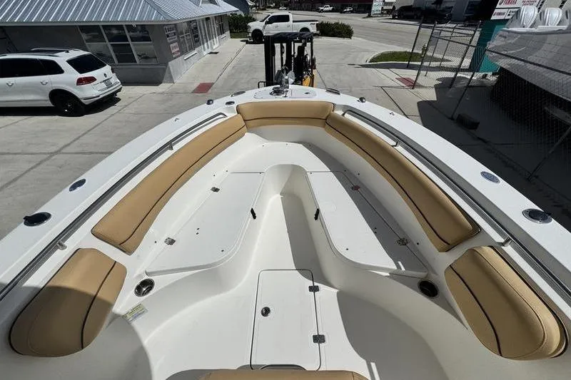 Slide: The Image of 2016 NauticStar 25 XS boat with tan seating, docked in a marina. - 11