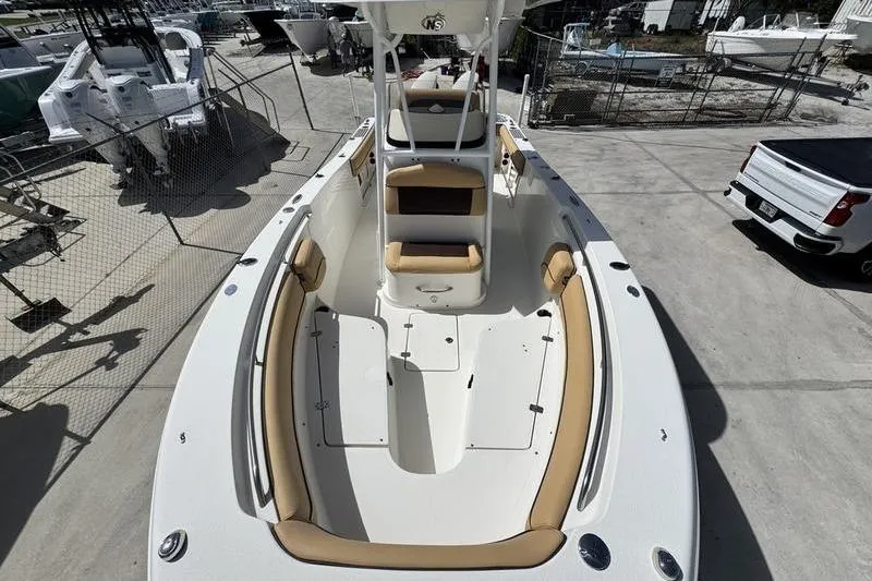 Slide: The Image of 2016 NauticStar 25 XS boat with tan seating, docked in a marina. - 13