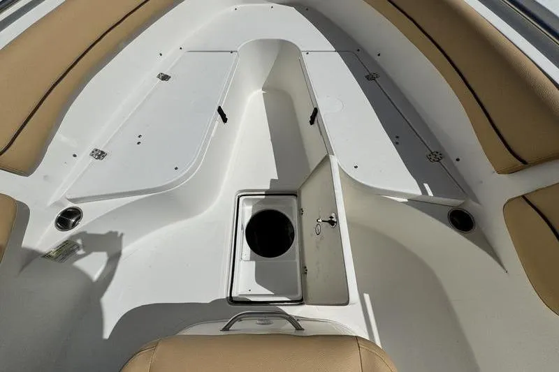 Slide: The Image of 2016 NauticStar 25 XS boat interior with tan seating and storage compartments. - 15