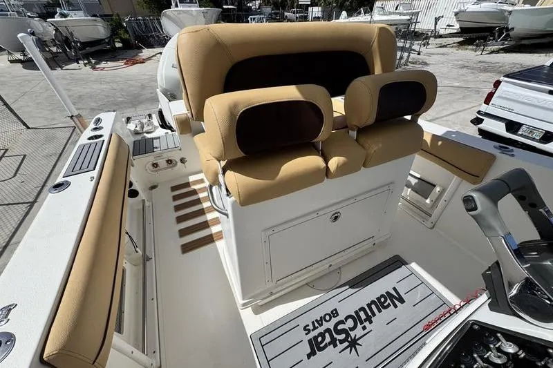 Slide: The Image of 2016 NauticStar 25 XS boat interior with tan seating and control panel. - 24