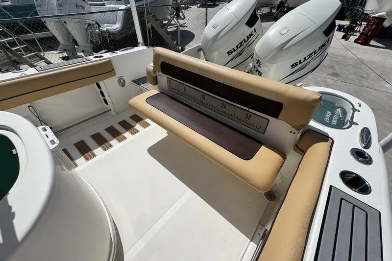 Slide: The Image of 2016 NauticStar 25 XS boat interior with tan seating and Suzuki outboard motors. - 27
