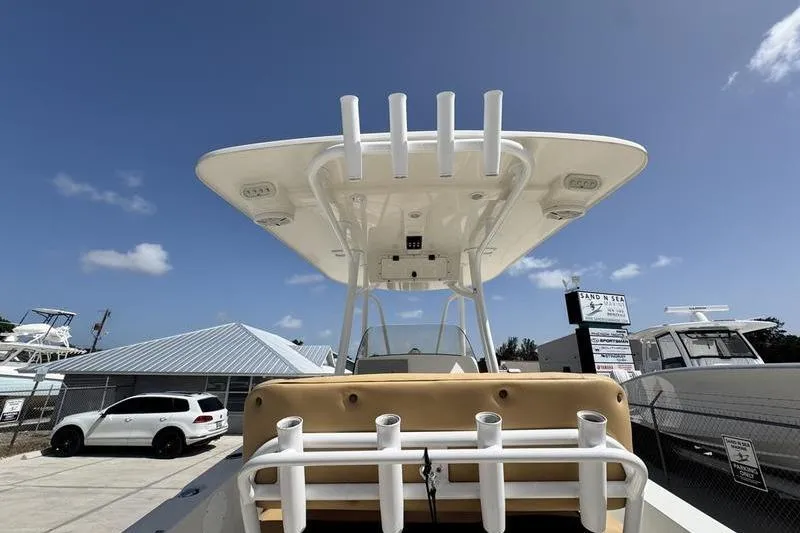 Slide: The Image of 2016 NauticStar 25 XS boat with T-top and rod holders, parked outdoors. - 30