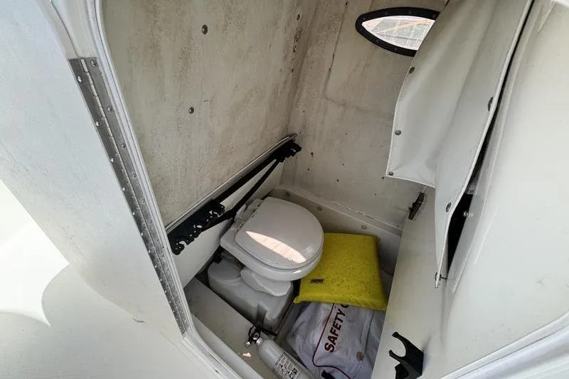 Slide: The Image of 2016 NauticStar 25 XS boat interior with toilet and safety equipment. - 32