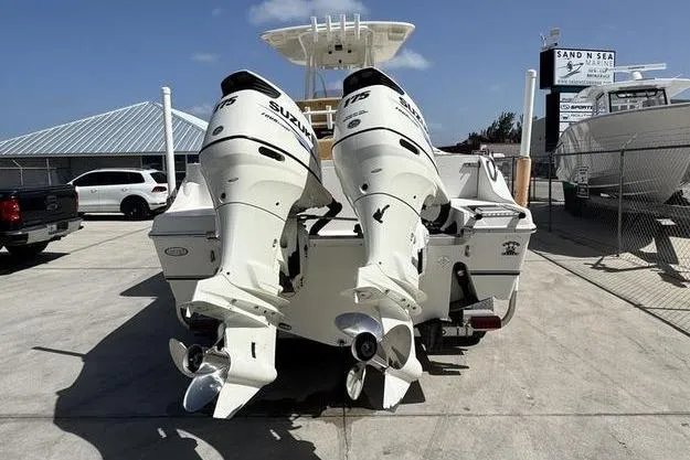 Slide: The Image of 2016 NauticStar 25 XS boat with twin Suzuki outboard motors at a marina. - 6