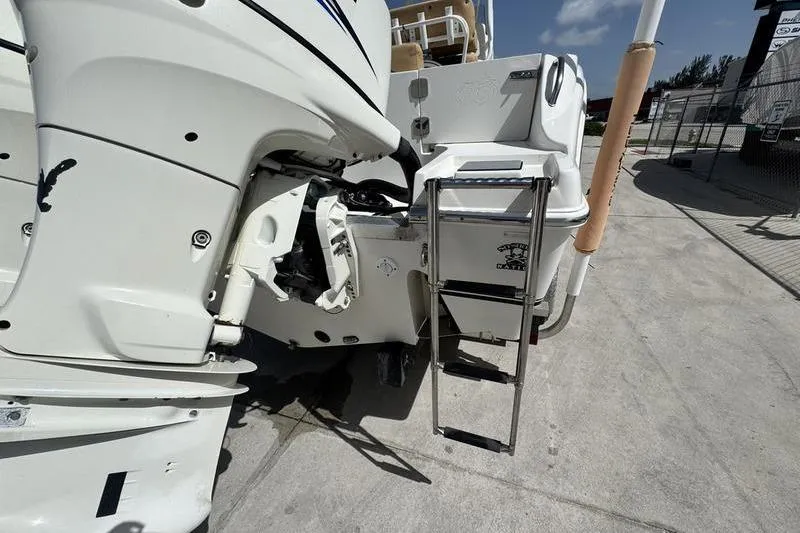 Slide: The Image of 2016 NauticStar 25 XS boat with ladder and outboard motor on a sunny day. - 8