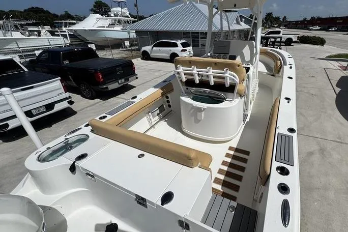 Slide: The Image of 2016 NauticStar 25 XS boat with tan seating, docked in a marina parking area. - 9