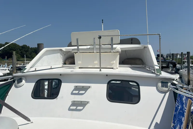 Slide: The Image of 1985 Rosborough RF-35 Atlantic Trawler docked, showcasing cabin and deck features under clear sky. - 13