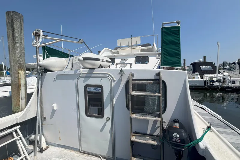 Slide: The Image of 1985 Rosborough RF-35 Atlantic Trawler docked at marina, featuring ladder and outboard motor. - 15