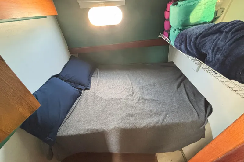 Slide: The Image of Cozy cabin bed in 1985 Rosborough RF-35 Atlantic Trawler with soft bedding and storage. - 16