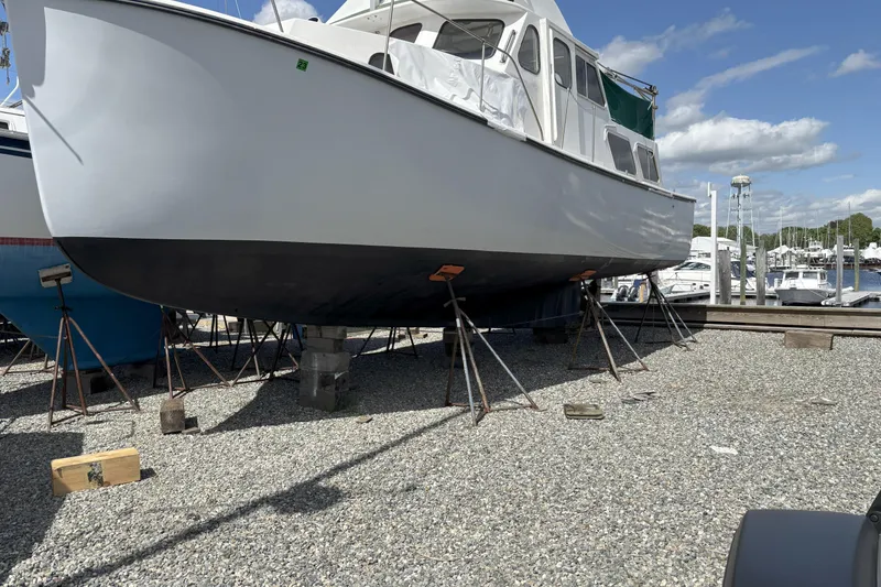 Slide: The Image of 1985 Rosborough RF-35 Atlantic Trawler on stands in a boatyard under a clear sky. - 3