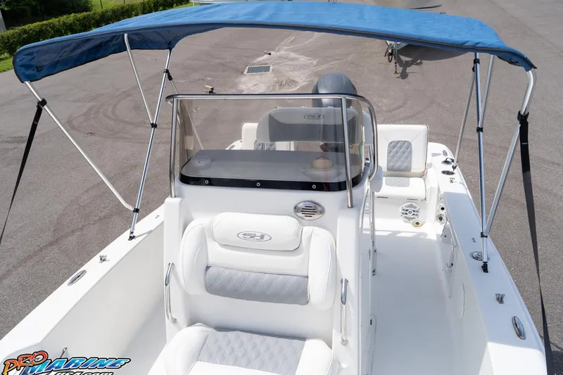 Slide: The Image of 2015 Sea Hunt BX 20 BR boat with blue canopy and white seating. - 37