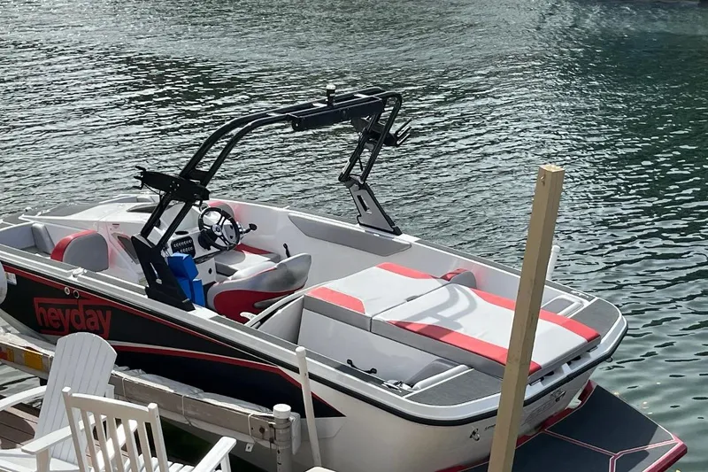 Slide: The Image of 2017 Heyday WT-1 boat docked on calm water, featuring red and white seating. - 13