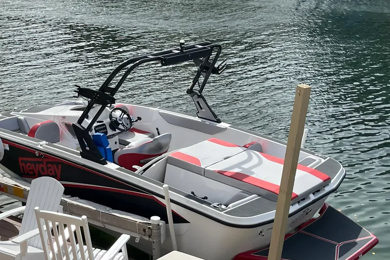 Slide: The Image of 2017 Heyday WT-1 boat docked on calm water, featuring sleek design and red accents. - 2
