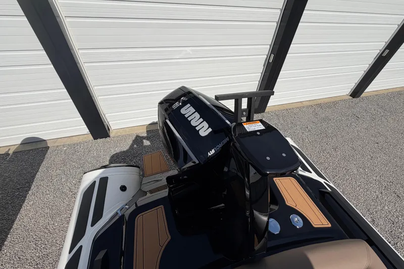 Slide: The Image of 2026 Brig Eagle 6.7 boat with Mercury engine, parked near a white garage door. - 13