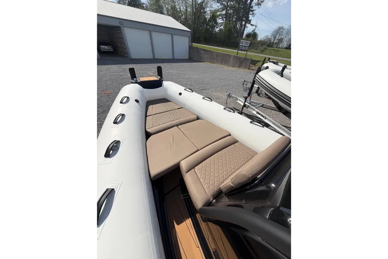 Slide: The Image of 2026 Brig Eagle 6.7 inflatable boat with beige seating, parked outdoors. - 8