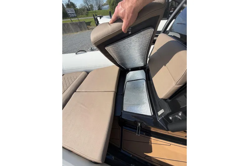 Slide: The Image of 2026 Brig Eagle 6.7 boat seat storage compartment with beige cushions and metallic interior. - 9