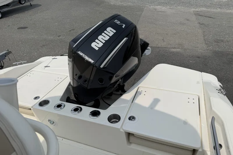Slide: The Image of 2024 Boston Whaler 220 Dauntless with Mercury V6 outboard engine, docked on pavement. - 10