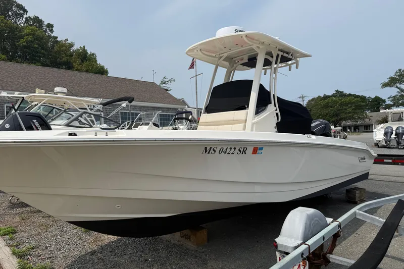 Slide: The Image of 2024 Boston Whaler 220 Dauntless boat on display in a marina setting. - 12
