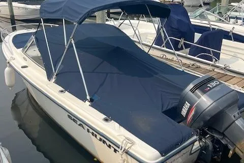 The Image of 2001 Sea Hunt 19 Dual Console boat with Yamaha 130 engine, docked with blue cover. - 1