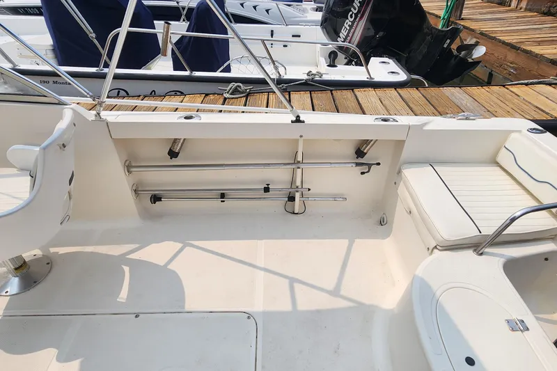 Slide: The Image of 2001 Sea Hunt 19 Dual Console boat interior with seating and fishing rod holders. - 10