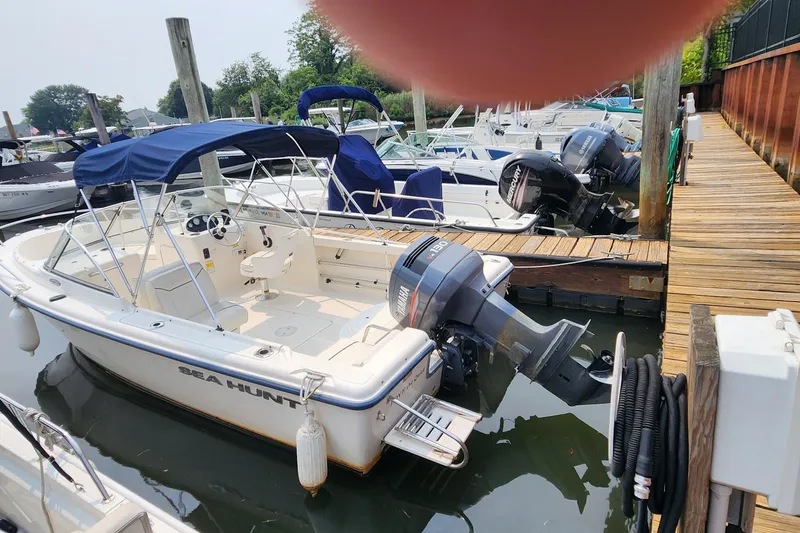 Slide: The Image of 2001 Sea Hunt 19 Dual Console boat docked with blue canopy and Yamaha outboard motor. - 16