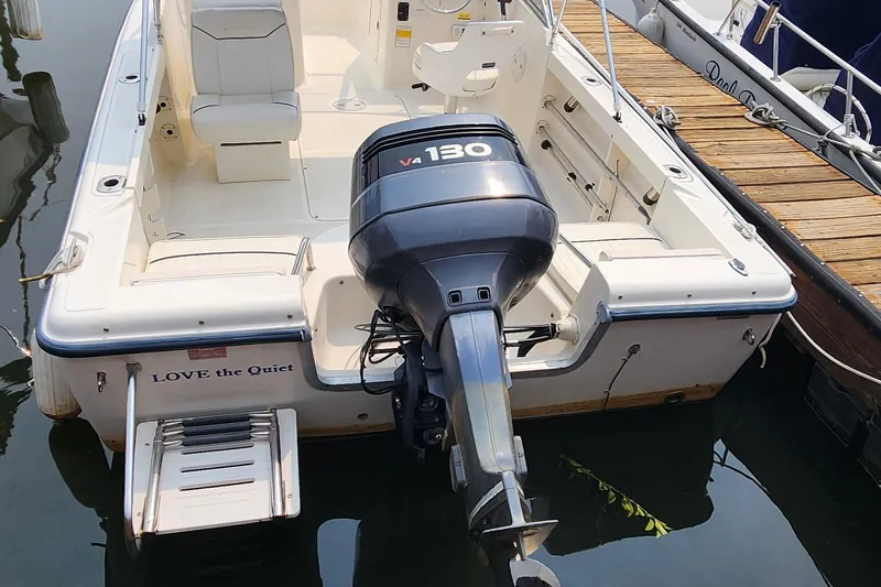 Slide: The Image of 2001 Sea Hunt 19 Dual Console boat with V4 130 engine, docked at marina. - 17